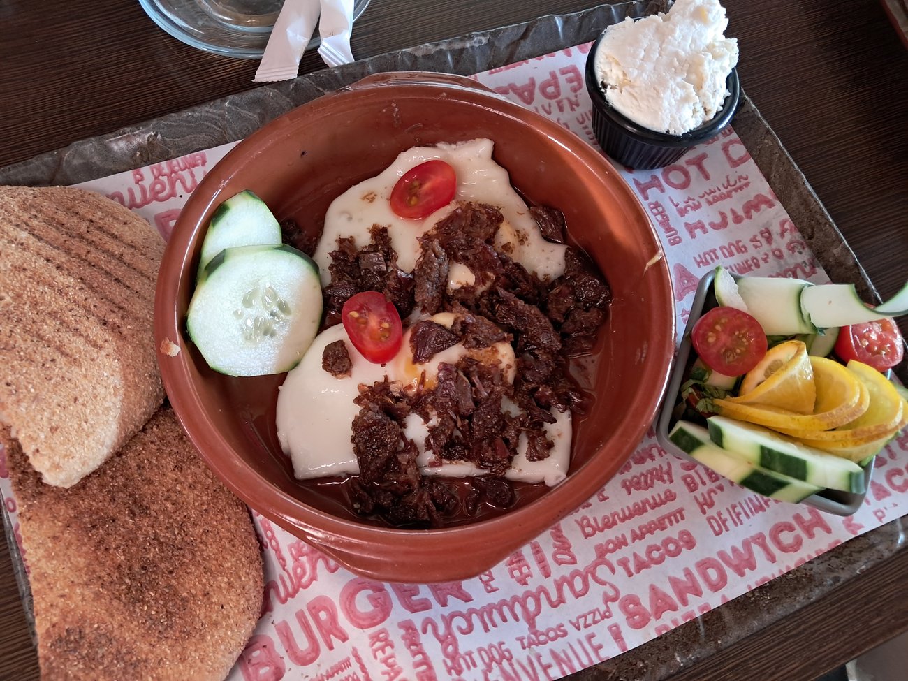 Khlii and eggs at Pizzeria Nour, Tangier — with bread, fresh veg and cream cheese